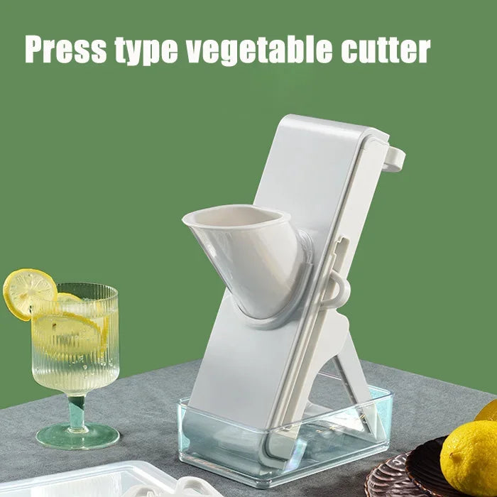 White press type vegetable cutter kitchen tool on gray surface with lemons and drink